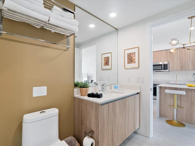 a bathroom with a granite countertop sink a toilet and a mirror