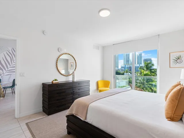 a bed sitting in a bedroom next to a window