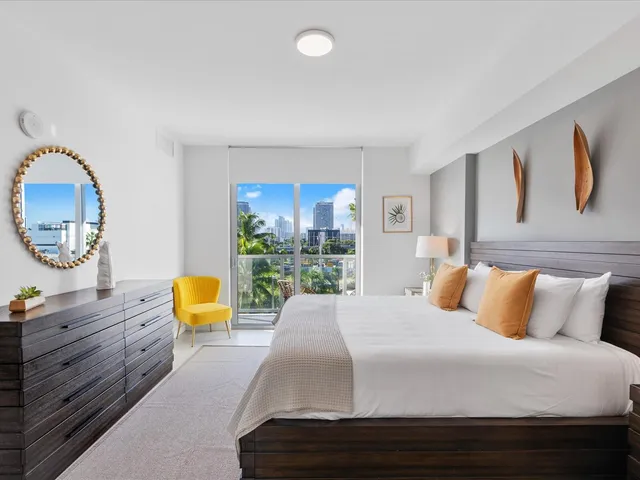 a bedroom with a bed a dresser and chair