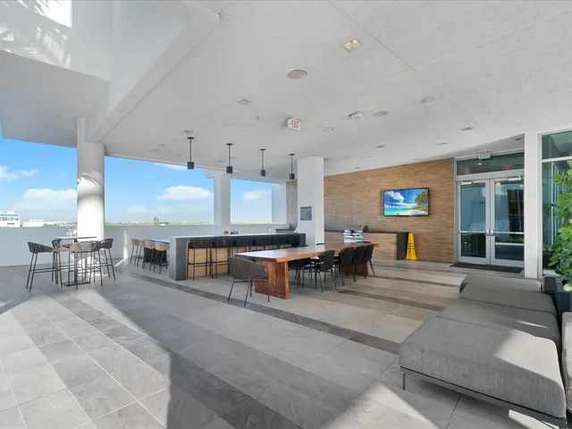 a living room with furniture pool table and large windows