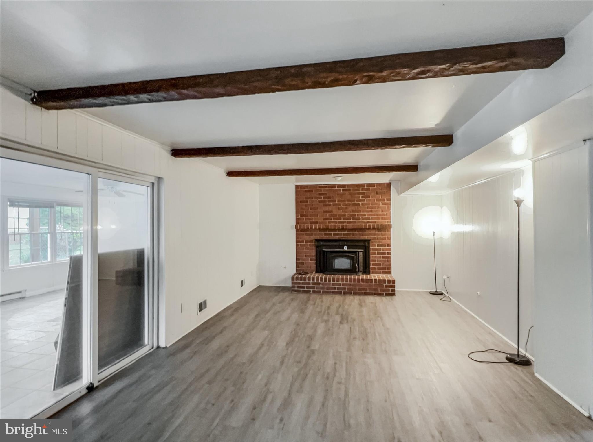 2618 Jonathan Road Ellicott City, MD 21042 - Photo 21 of 32 a view of an empty room with wooden floor a fireplace and a window