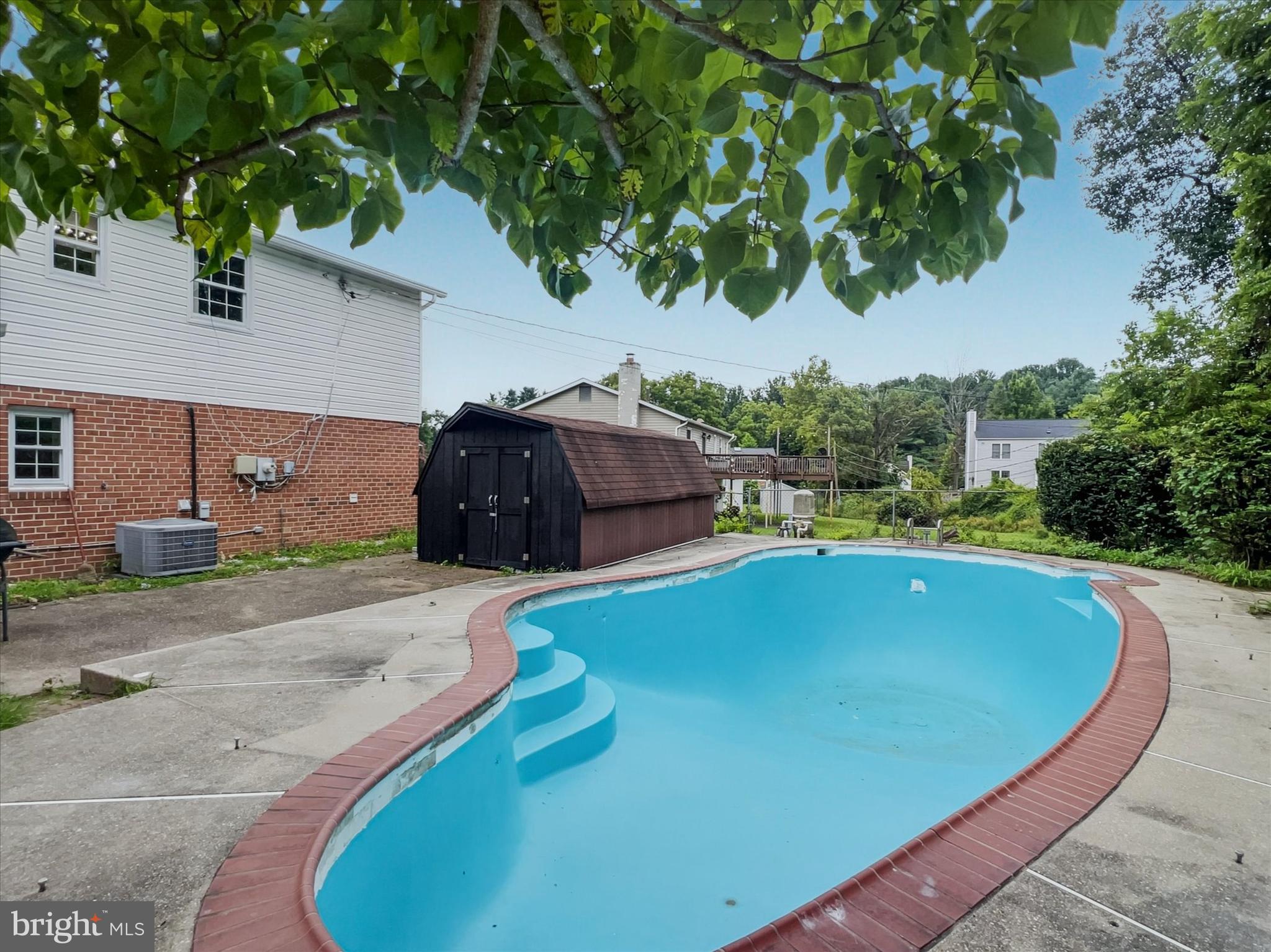 2618 Jonathan Road Ellicott City, MD 21042 - Photo 30 of 32 a view of a swimming pool with lawn chairs under an umbrella