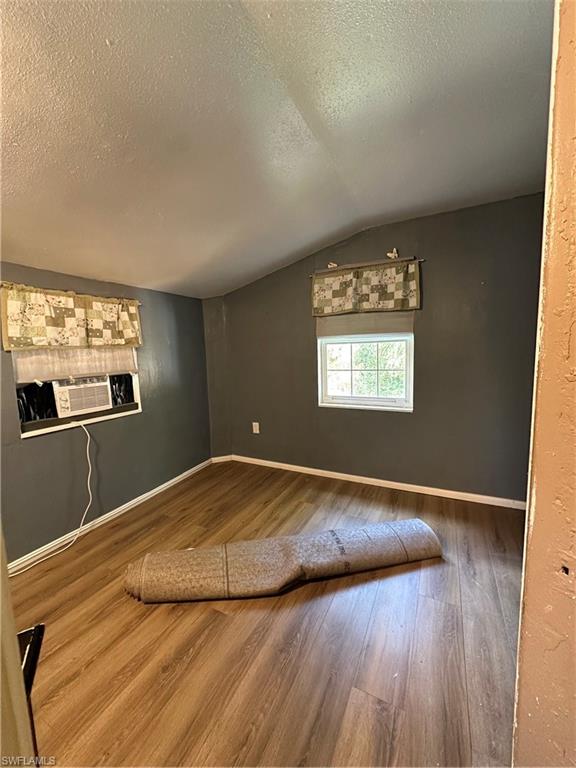 18301 Slater Road North Fort Myers, FL 33917 - Photo 6 of 17 a view of empty room with wooden floor and kitchen view