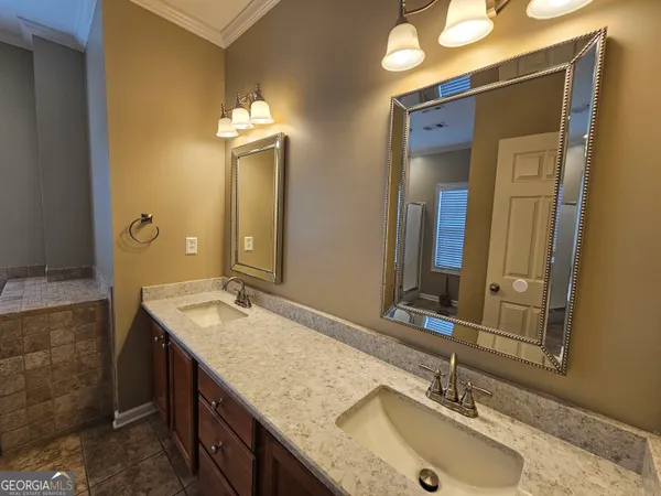 a bathroom with double vanity sinks and a mirror