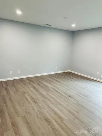 a kitchen with stainless steel appliances granite countertop a sink a stove a refrigerator and white cabinets