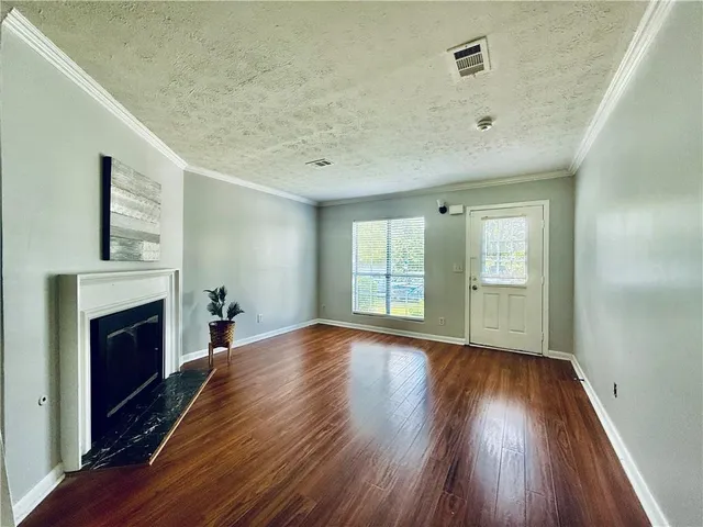 a view of empty room with wooden floor and fireplace
