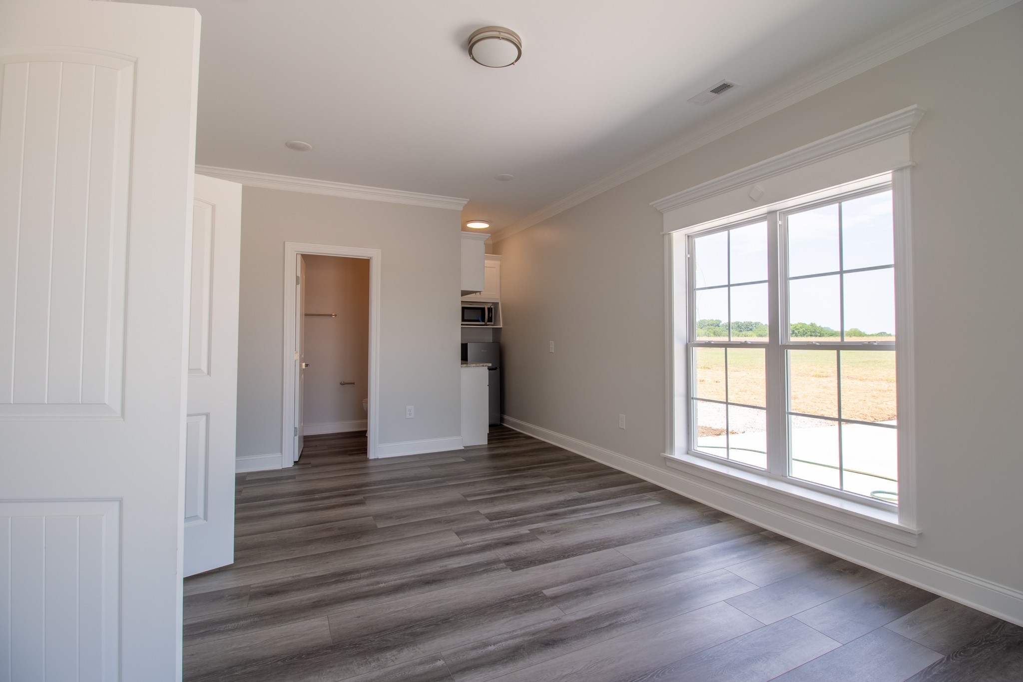 935 South Cross Bridges Road Mount Pleasant, TN 38474 - Photo 29 of 44 an empty room with wooden floor and windows