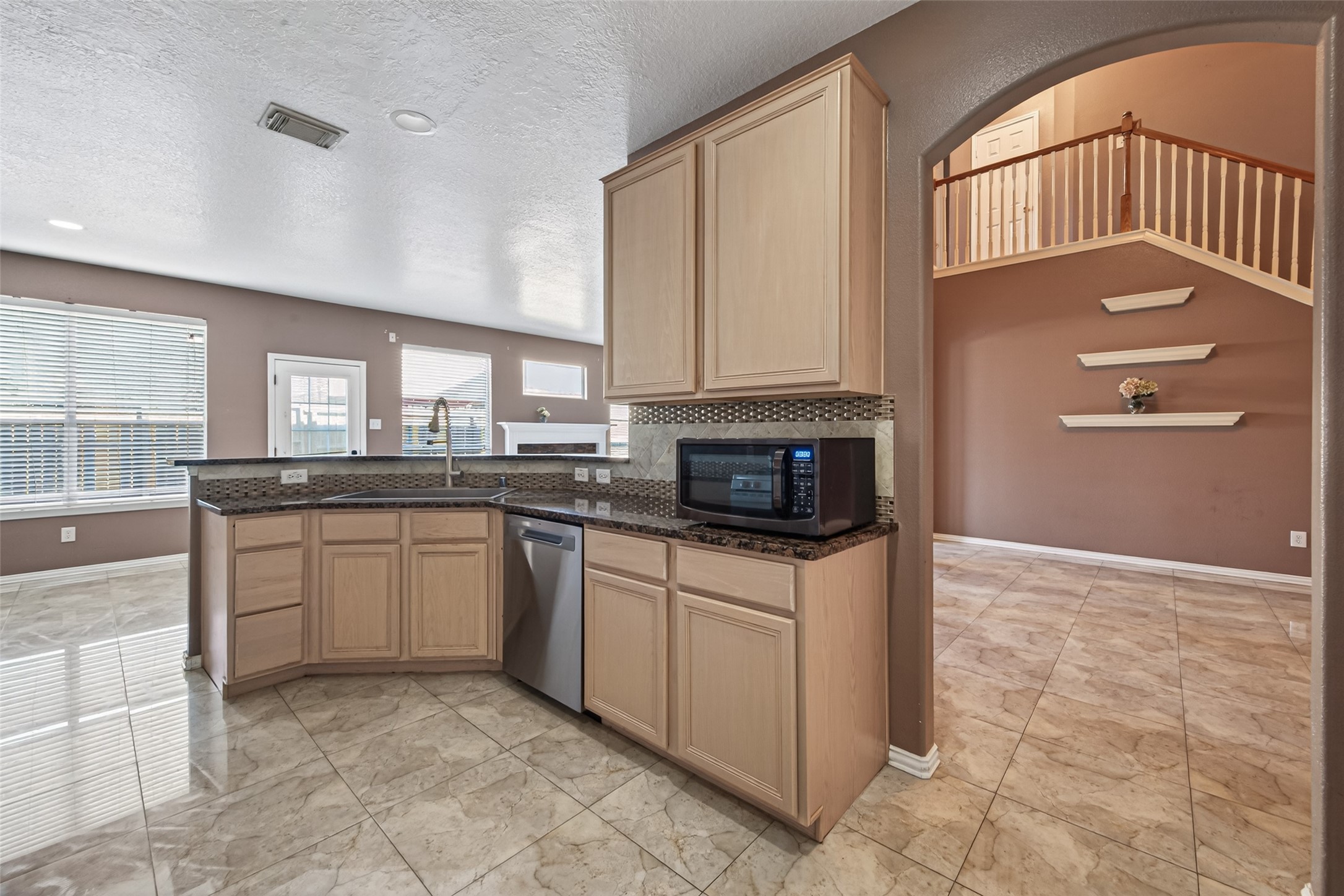 18818 Flagstone Creek Road Houston, TX 77084 - Photo 12 of 47 a kitchen with stainless steel appliances granite countertop a stove a sink and a microwave