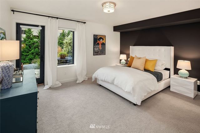 a bedroom with a bed and a large window