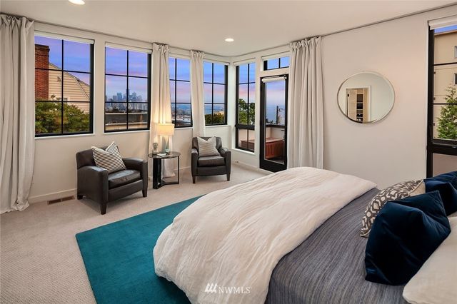 a bedroom with a bed couch and a large window