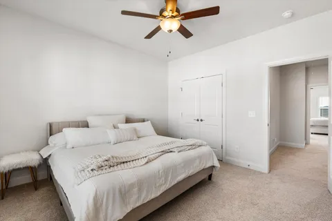 a bedroom with a bed and a ceiling fan