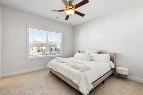a bedroom with a bed lamp and window