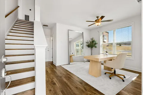 a view of a workspace with wooden floor and a chandelier