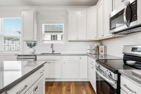 a kitchen with stainless steel appliances granite countertop a sink and a stove