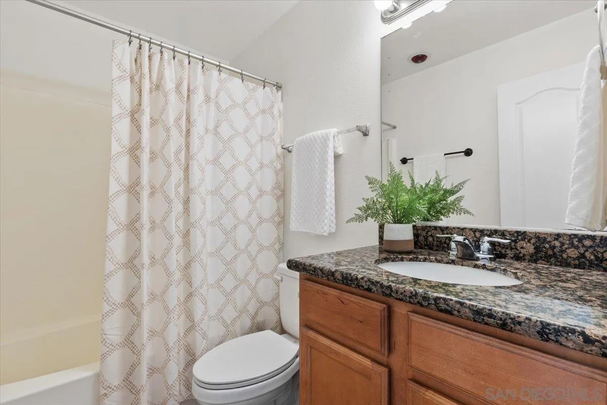 6333 Mt Ada Road, Unit 279 San Diego, CA 92111 - Photo 14 of 21 a bathroom with a granite countertop sink and a mirror