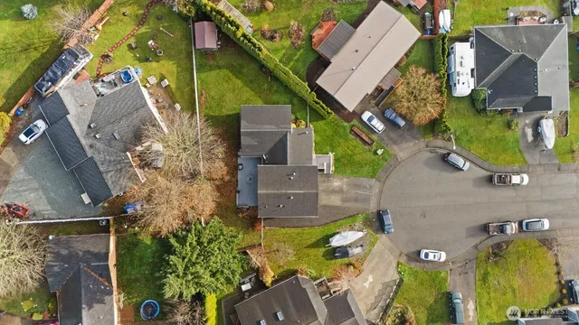 an aerial view of a house with a yard and large tree