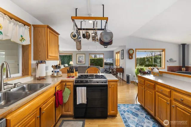 a kitchen with stainless steel appliances granite countertop a stove a sink and a microwave