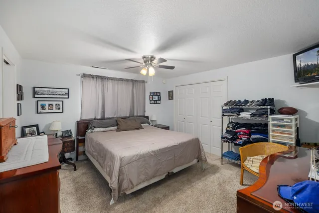 a bedroom with a bed a couch and a flat screen tv