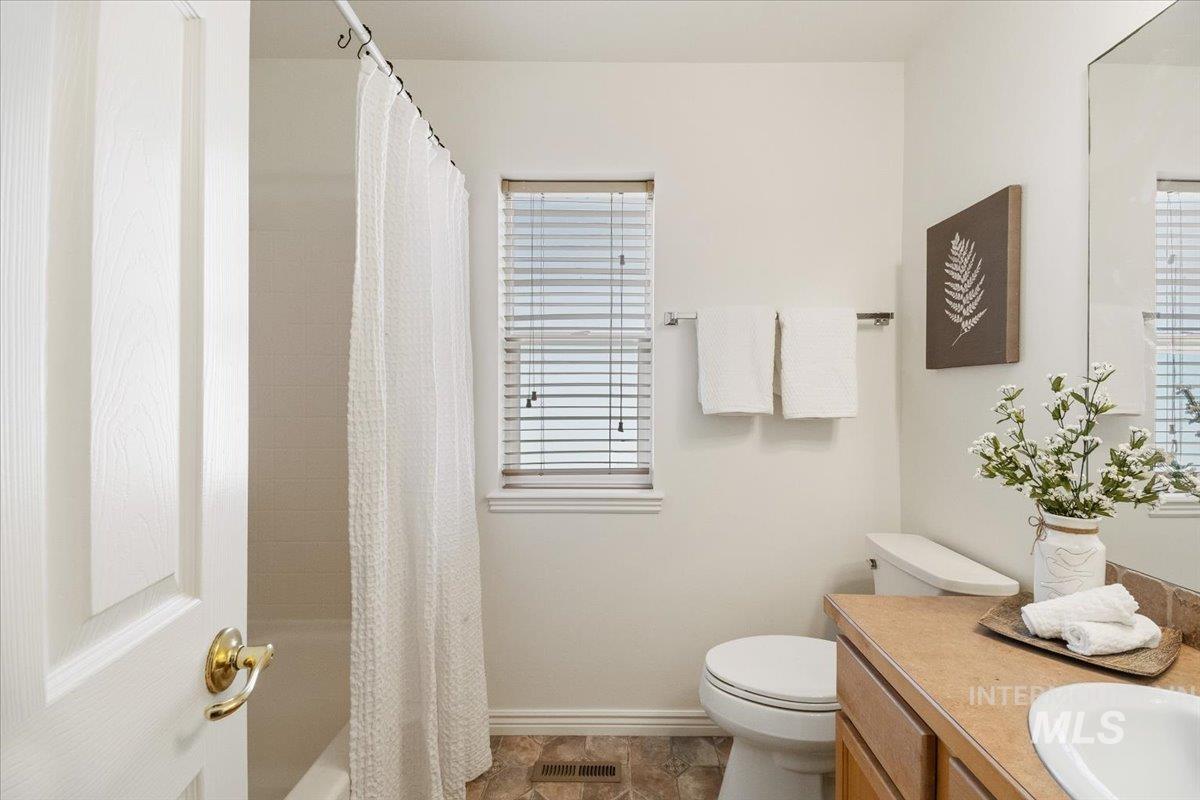 2032 Talus Loop Twin Falls, ID 83301 - Photo 27 of 43 Full bathroom featuring a window with horizontal blinds, a white toilet, and a vanity with a counter and an integrated sink