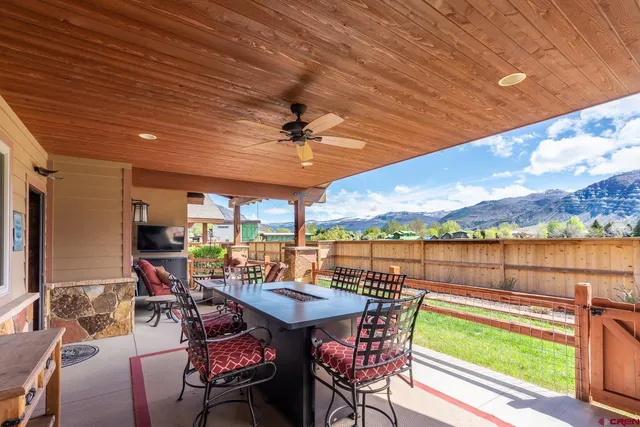 a view of a patio with table and chairs barbeque potted plants and large tree