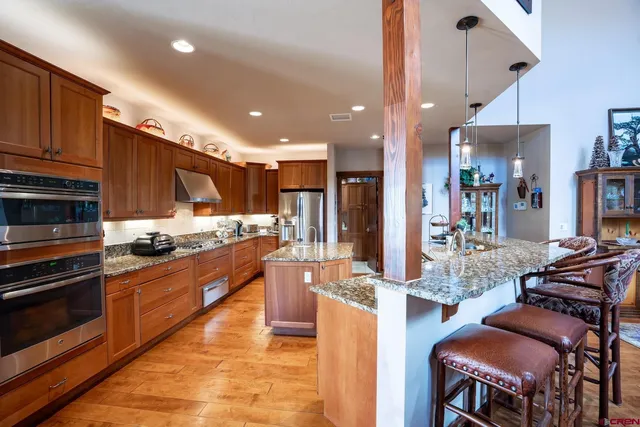 a large kitchen with stainless steel appliances kitchen island granite countertop a stove and cabinets