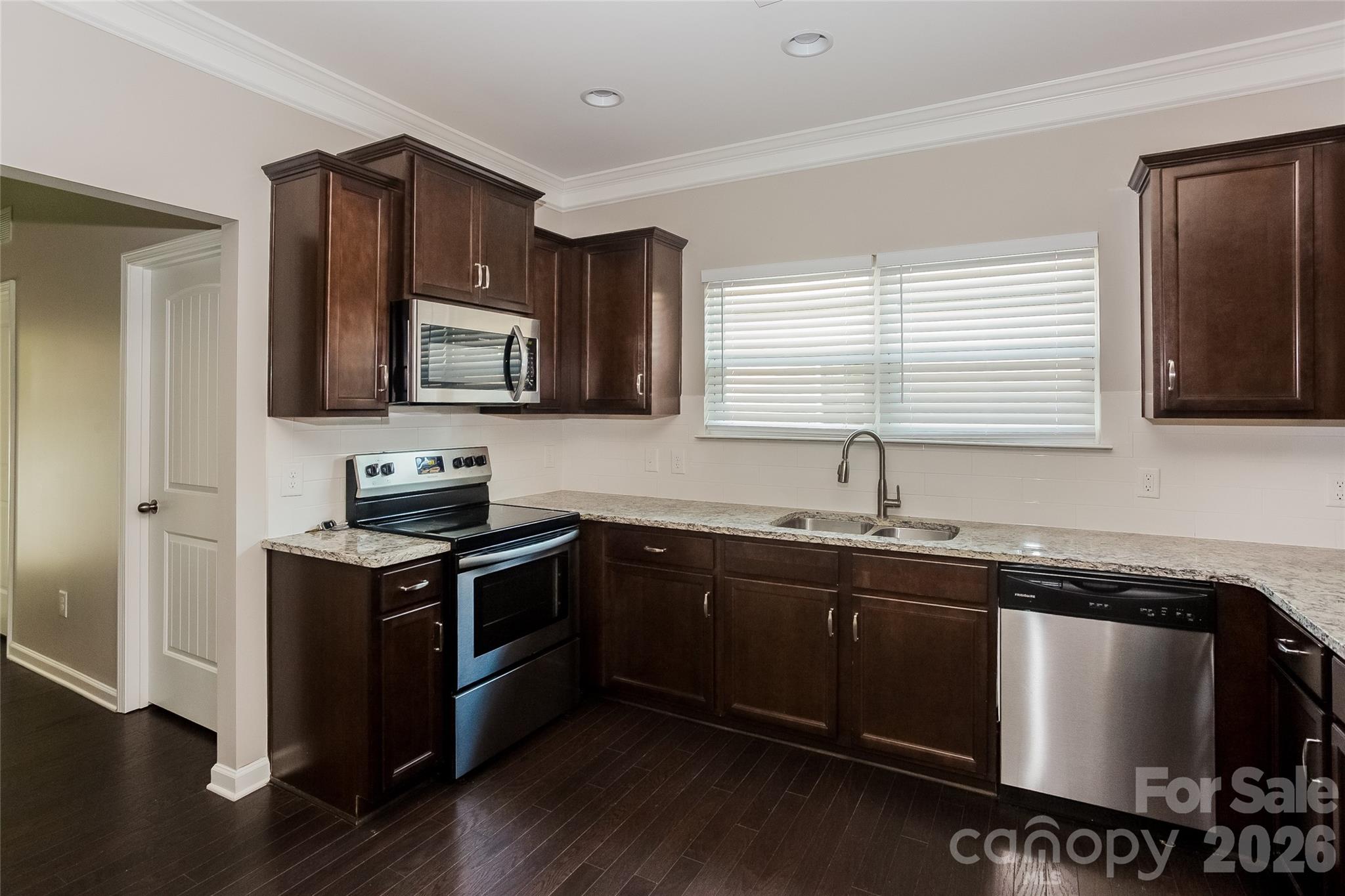 288 Harrison Lane Locust, NC 28097 - Photo 6 of 15 a kitchen with stainless steel appliances granite countertop a sink stove and microwave