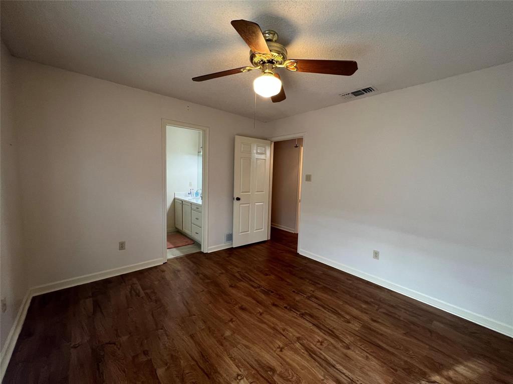 3129 Sappington Place Fort Worth, TX 76116 - Photo 8 of 15 Unfurnished bedroom featuring dark wood-type flooring, ceiling fan, a textured ceiling, and ensuite bath