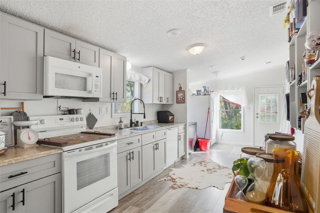 17539 Edwin Terrace Hudson, FL 34667 - Photo 14 of 38 a kitchen with a sink stove and white cabinets