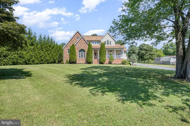 a front view of a house with a garden and trees