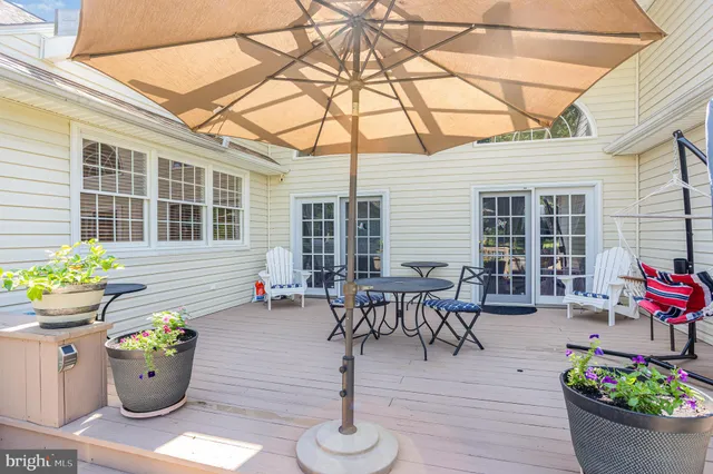 a view of a dining room with wooden chairs and potted plants