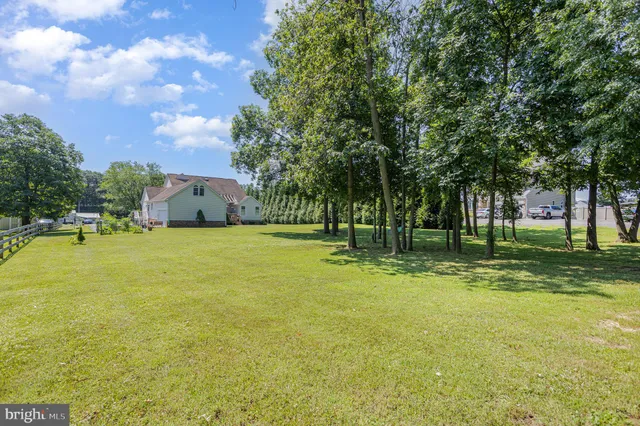 a view of an house with swimming pool and trees in the background