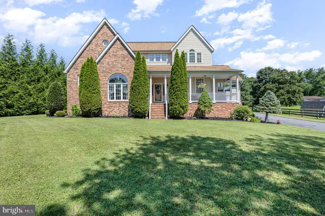 a front view of a house with yard and green space