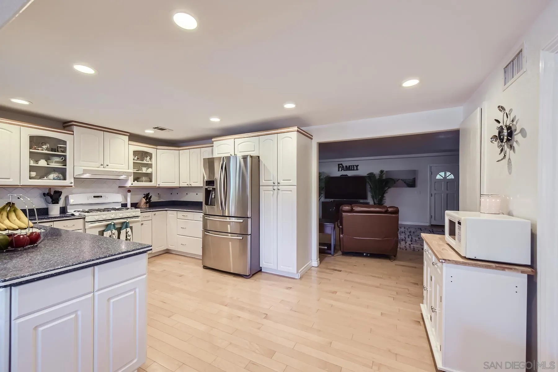 8510 Rumson Drive Santee, CA 92071 - Photo 9 of 26 a kitchen with refrigerator a microwave a stove and white cabinets
