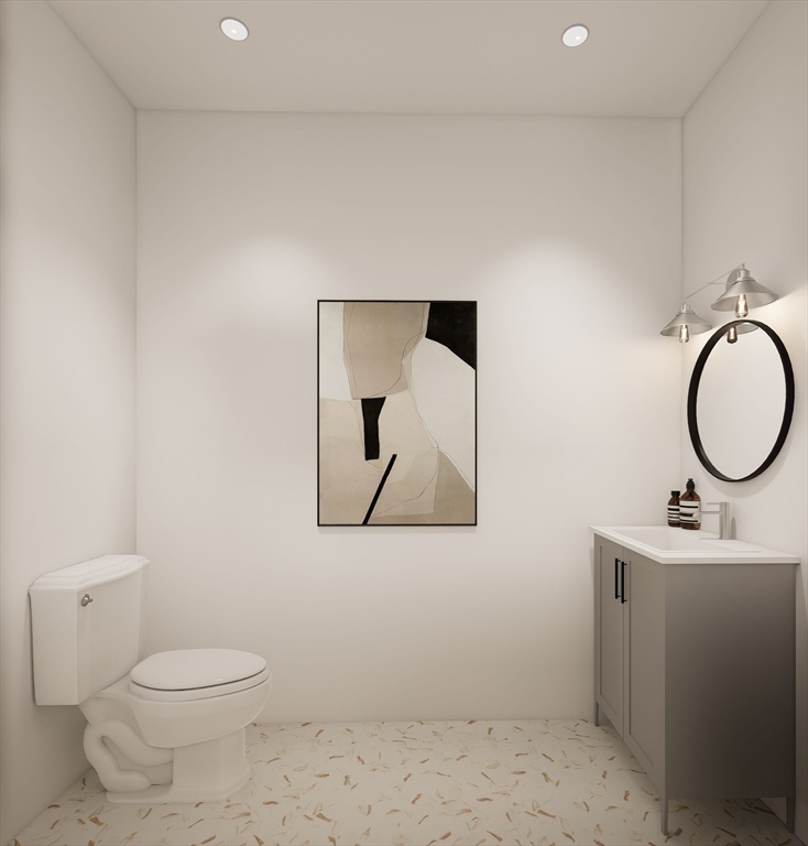 11 Whitman Circle, Unit 11 Bellingham, MA 02019 - Photo 11 of 19 a bathroom with a toilet sink vanity and mirror