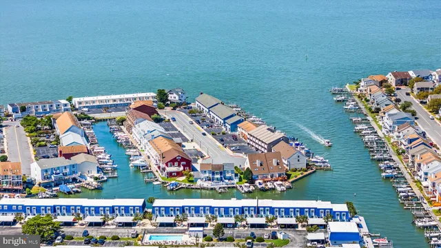 an aerial view of ocean and residential houses with outdoor space
