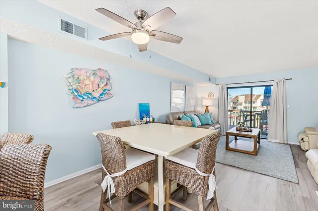 a view of a dining room with furniture a chandelier and wooden floor