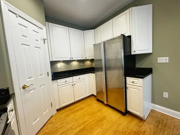 a kitchen with a refrigerator sink and cabinets
