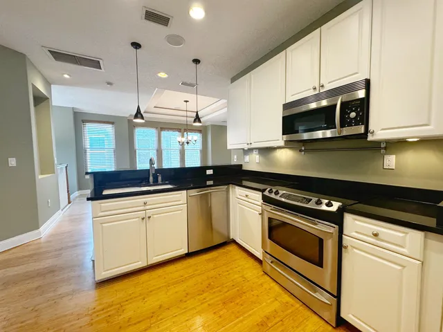 a kitchen with stainless steel appliances granite countertop a stove a sink and a microwave