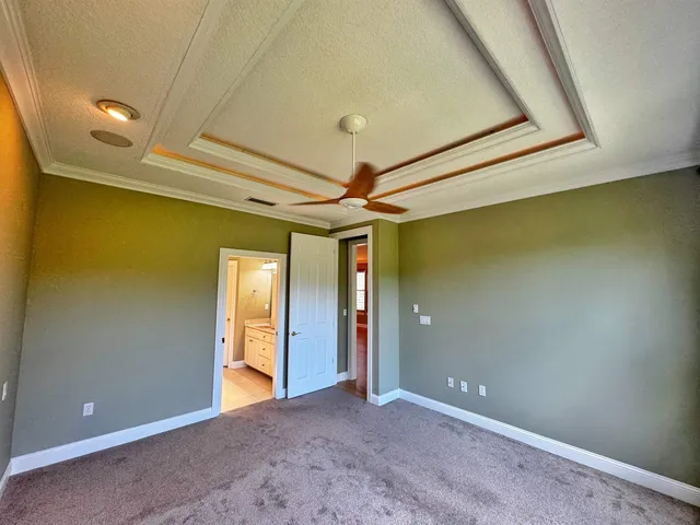 an empty room with fan and windows