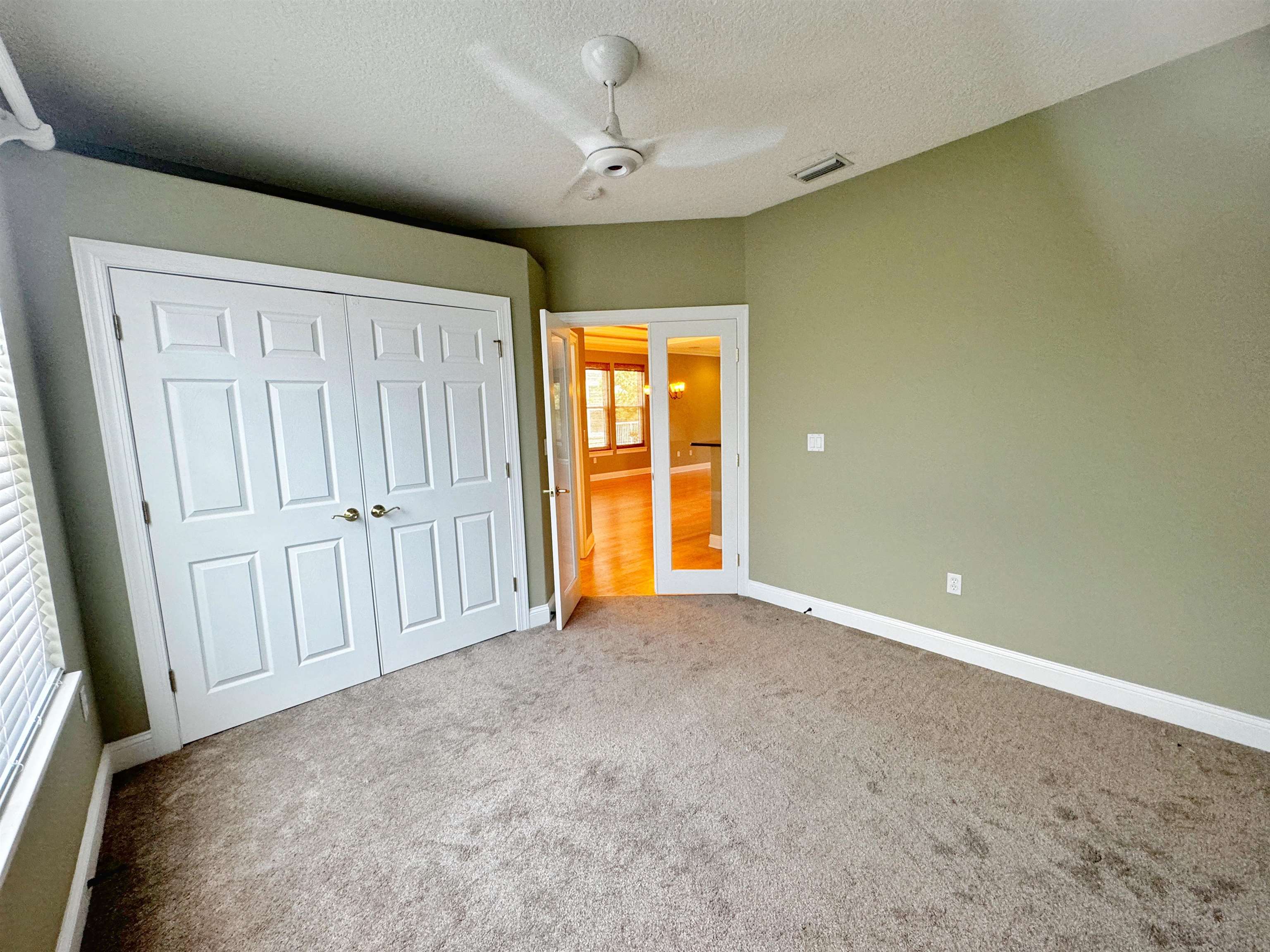 113 Sunset Circle South St. Augustine, FL 32080 - Photo 21 of 33 an empty room with windows and a ceiling fan