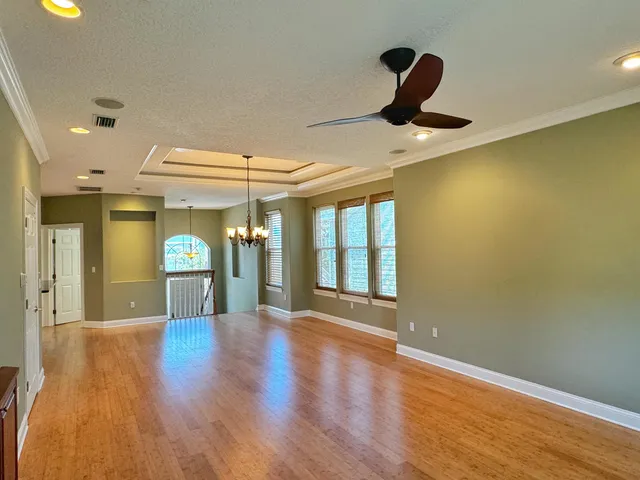 a view of a livingroom with wooden floor and a large window