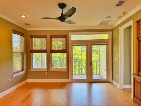 a view of an empty room with a window and wooden floor