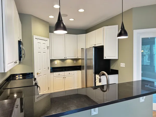 a kitchen with stainless steel appliances granite countertop a sink a stove and a refrigerator