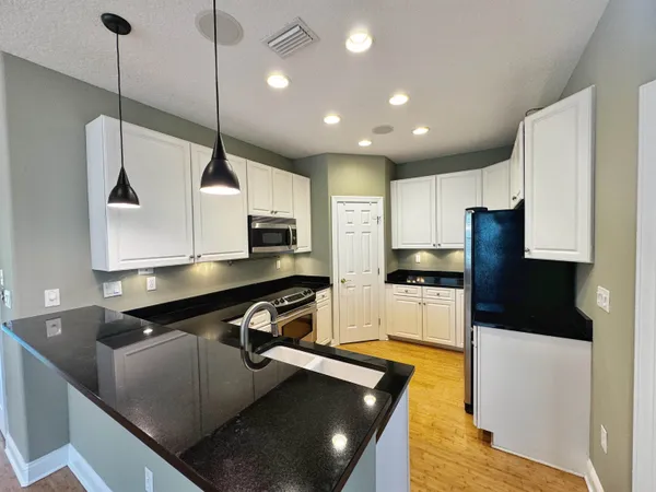 a kitchen with stainless steel appliances granite countertop a sink a stove and a refrigerator