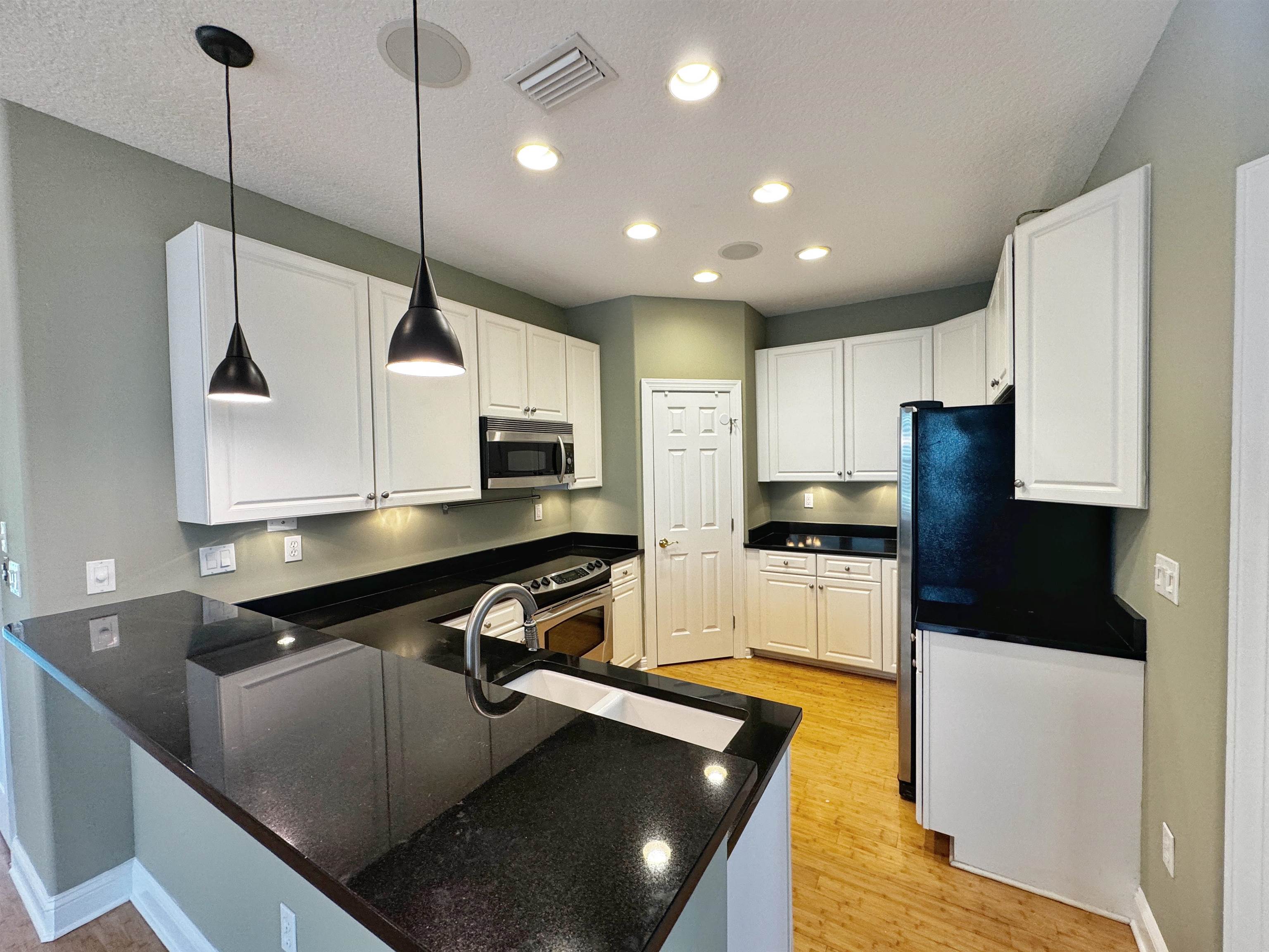 113 Sunset Circle South St. Augustine, FL 32080 - Photo 10 of 33 a kitchen with stainless steel appliances granite countertop a sink a stove and a refrigerator