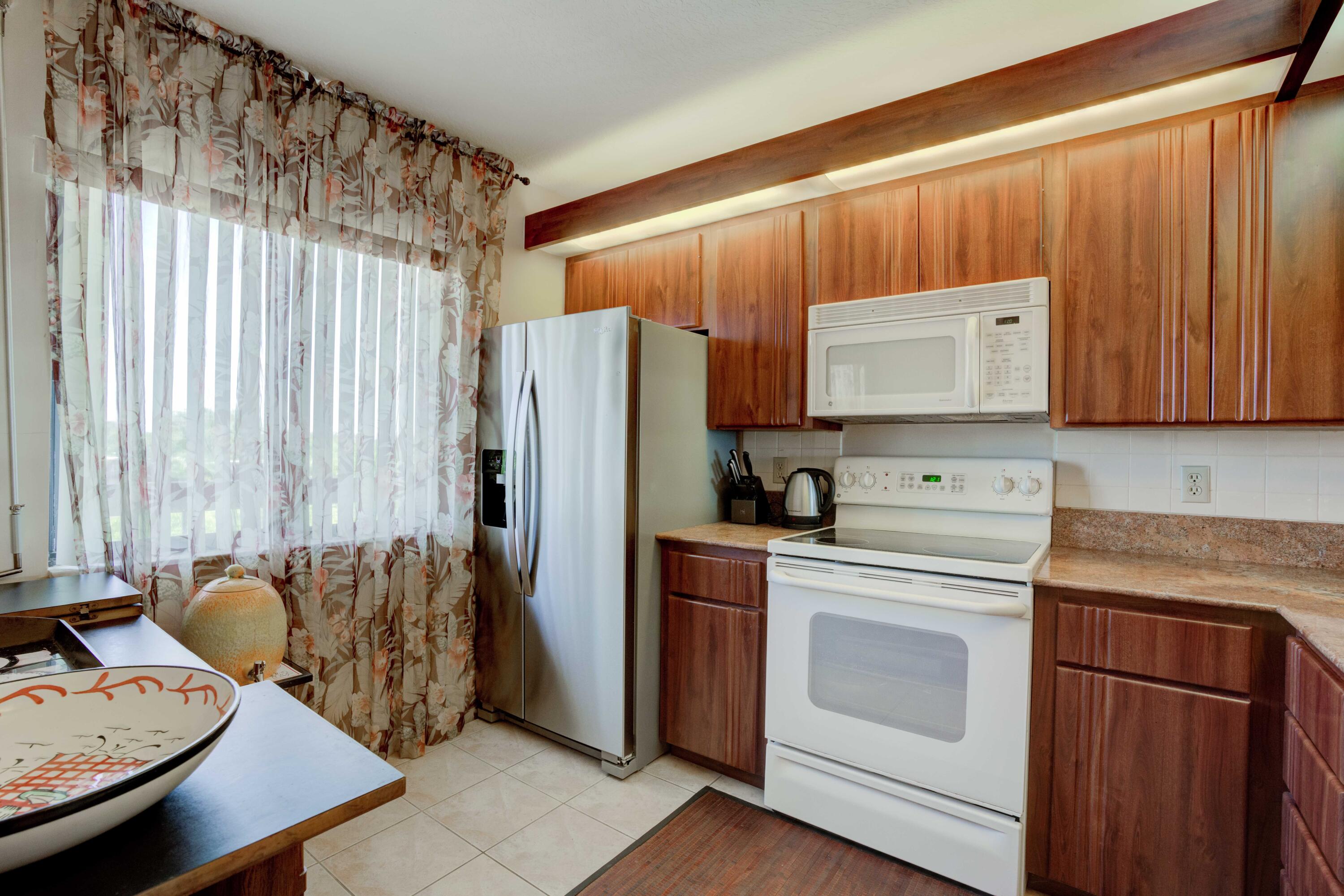 801 Seafarer Circle, Unit 404 Jupiter, FL 33477 - Photo 15 of 34 a kitchen with stainless steel appliances granite countertop a refrigerator sink and stove
