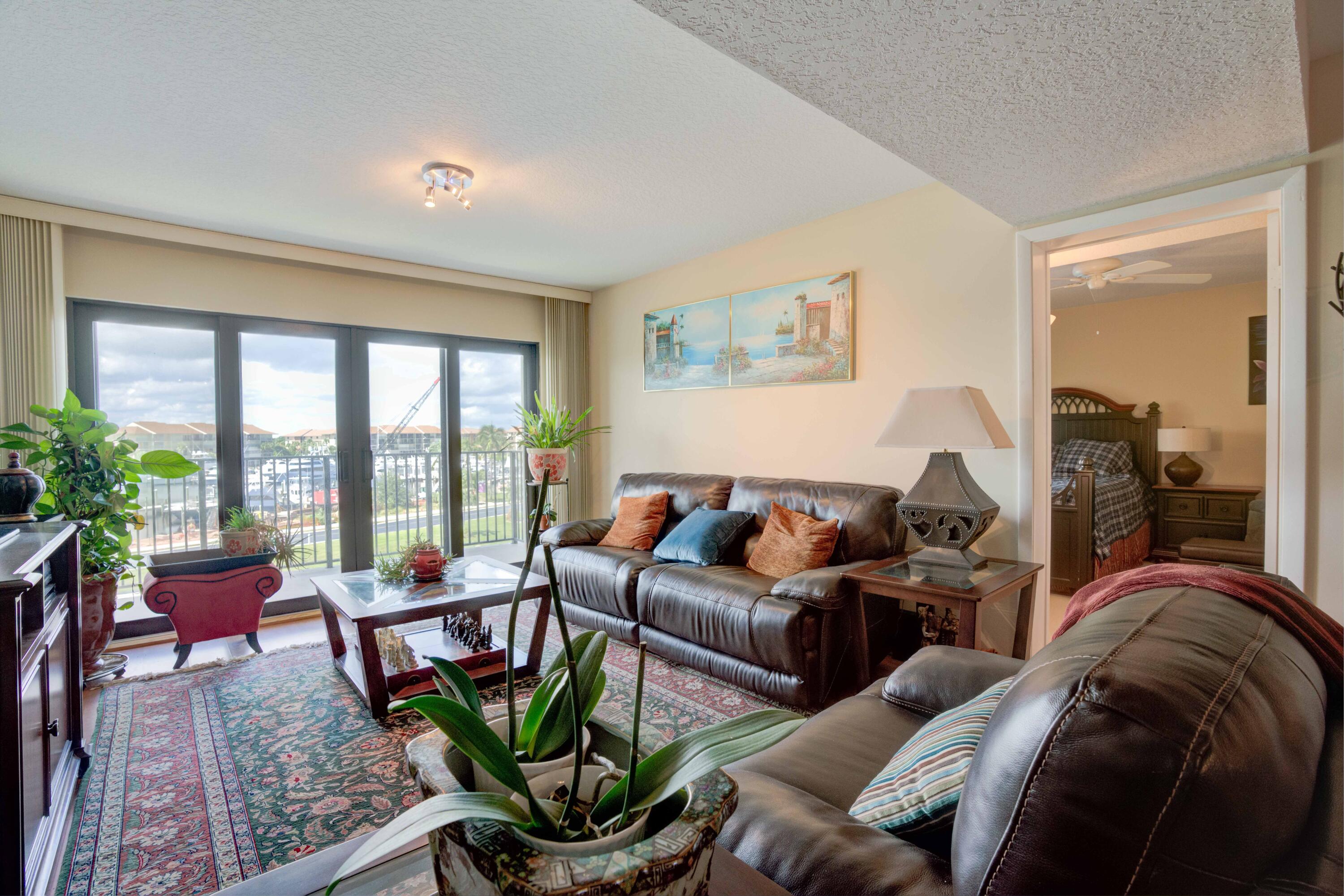 801 Seafarer Circle, Unit 404 Jupiter, FL 33477 - Photo 22 of 34 a living room with furniture potted plant floor to ceiling windows and a potted plant