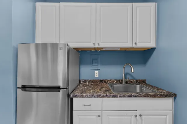 a kitchen with refrigerator and cabinets