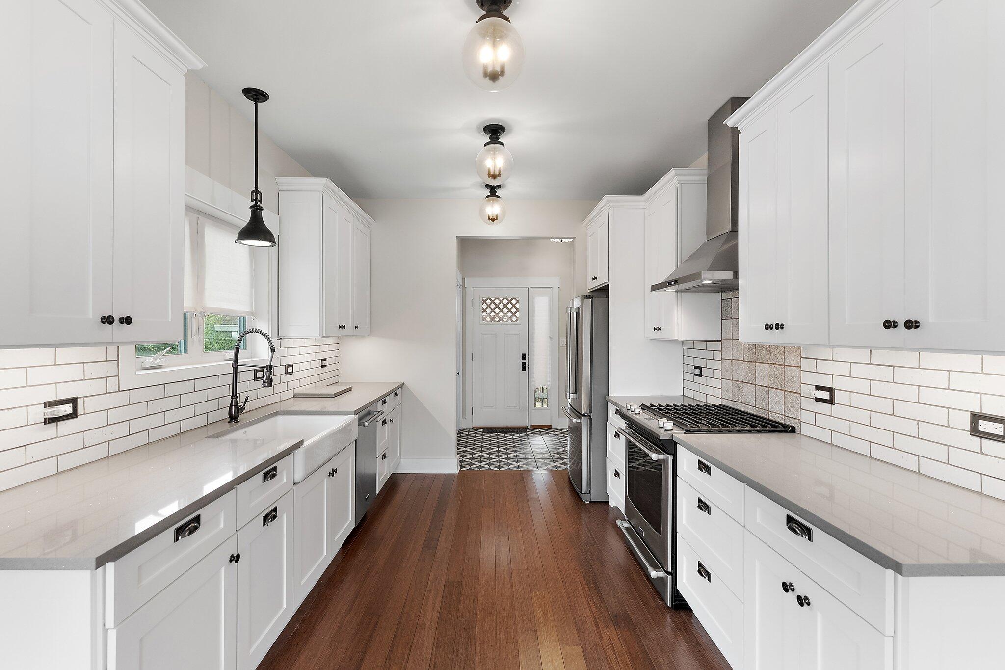 Undisclosed Address Whiting, IN 46394 - Photo 4 of 21 a kitchen with kitchen island white cabinets sink and stainless steel appliances