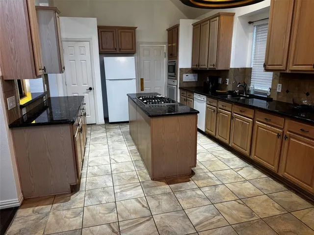 a kitchen with stainless steel appliances granite countertop a sink stove and cabinets